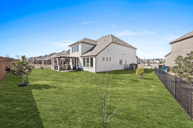 rear view of property featuring roof with shingles, a fenced backyard, a lawn, a patio area, and brick siding