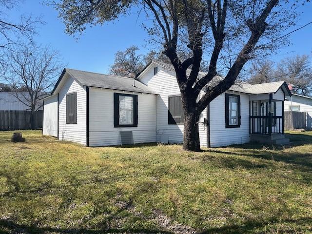 view of home's exterior with a lawn and fence