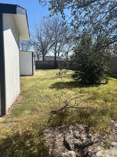 view of yard featuring an outdoor structure and fence