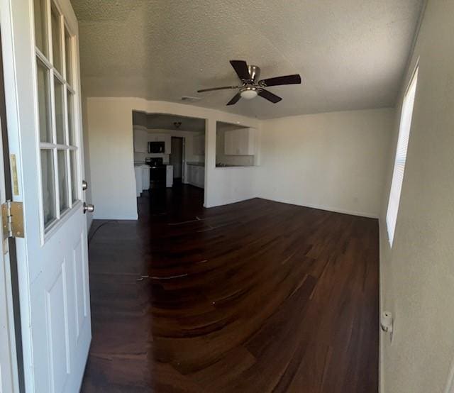 unfurnished room with dark wood finished floors, a textured ceiling, and ceiling fan