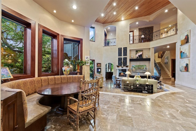 dining space with breakfast area, stairs, recessed lighting, wooden ceiling, and a towering ceiling