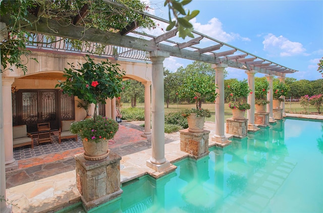 outdoor pool with a patio area and a pergola