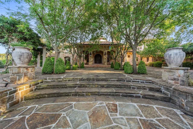 view of front facade with a tiled roof and stone siding