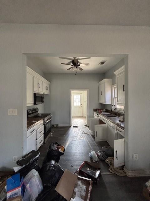 kitchen featuring stainless steel microwave, electric range oven, white cabinetry, ceiling fan, and dark wood-style flooring