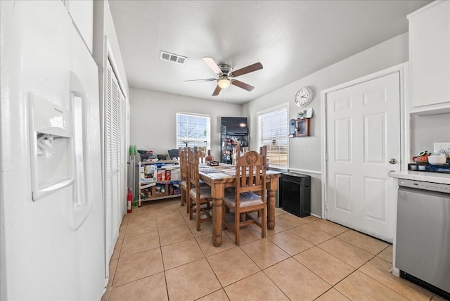 dining area with light tile patterned floors, visible vents, and a ceiling fan