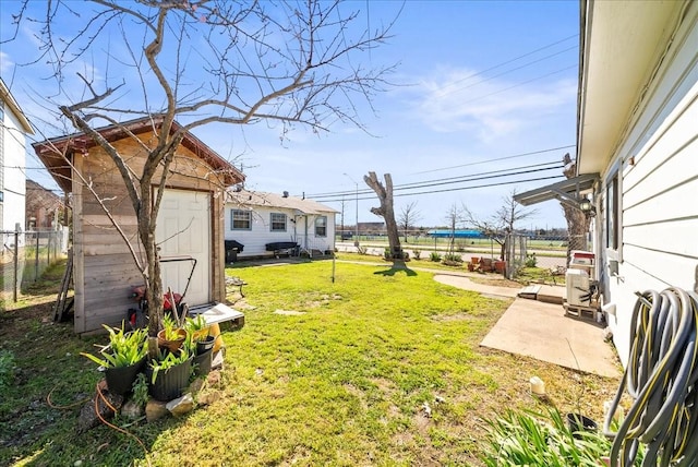 view of yard with an outdoor structure, a shed, and fence