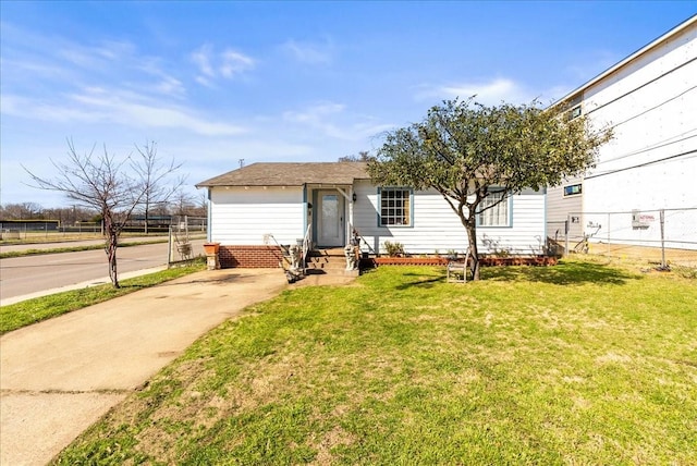 view of front of home with a front lawn and fence