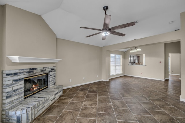 unfurnished living room with ceiling fan, baseboards, lofted ceiling, and a glass covered fireplace