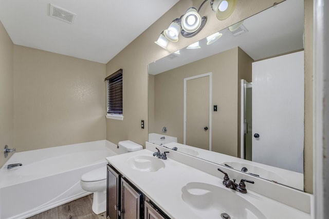 full bath featuring toilet, a bath, visible vents, and a sink