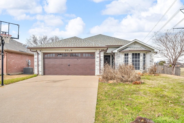 ranch-style home with a shingled roof, fence, concrete driveway, a front yard, and a garage