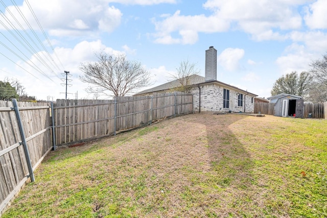 view of yard with an outdoor structure, a fenced backyard, and a shed