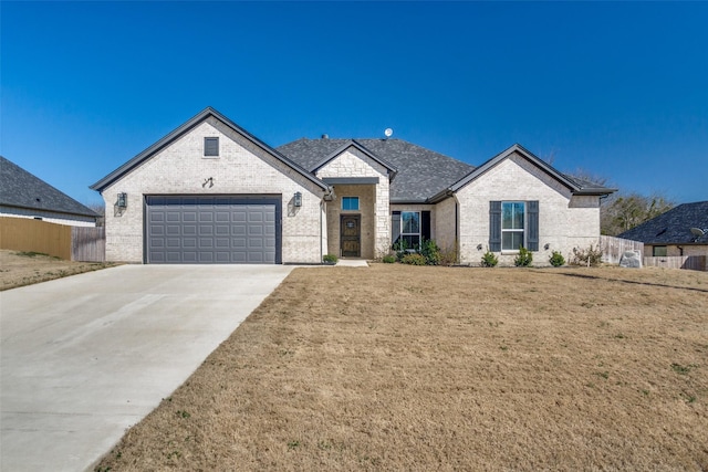 french country style house with a front lawn, driveway, fence, an attached garage, and brick siding