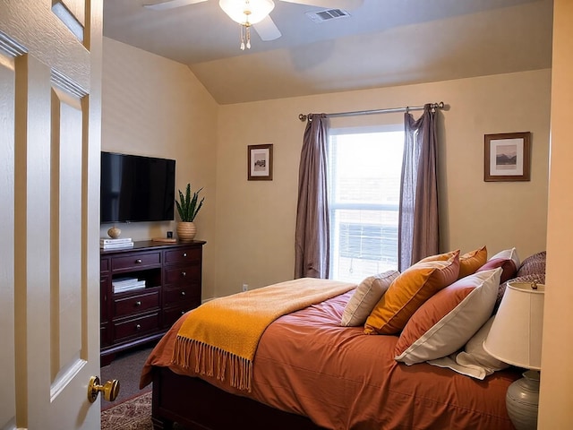 bedroom featuring lofted ceiling, visible vents, dark colored carpet, and ceiling fan