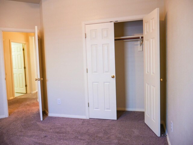 unfurnished bedroom featuring carpet flooring, baseboards, and a closet