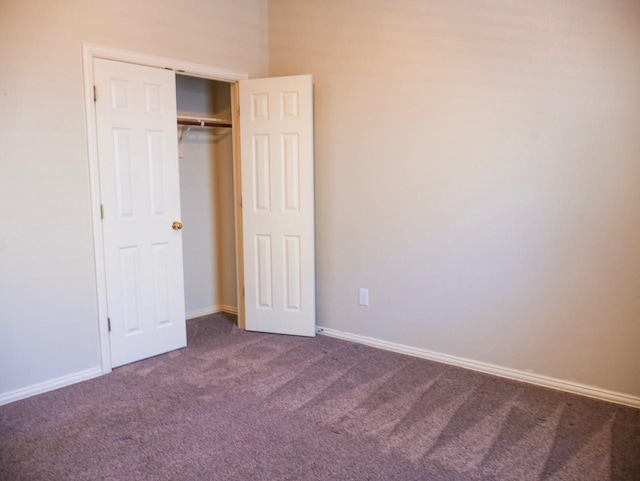 unfurnished bedroom with a closet, baseboards, and carpet