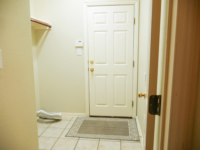 laundry area featuring light tile patterned floors and baseboards