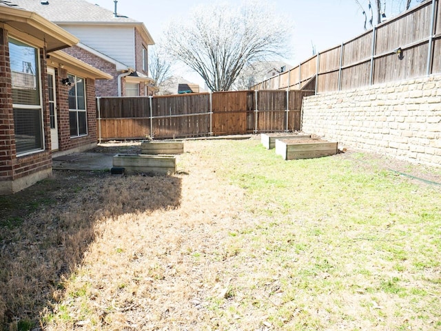 view of yard featuring a vegetable garden and a fenced backyard