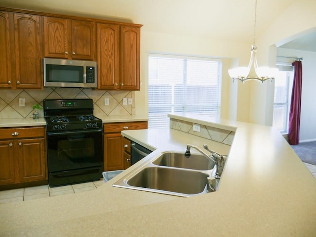 kitchen featuring a sink, backsplash, appliances with stainless steel finishes, and light countertops