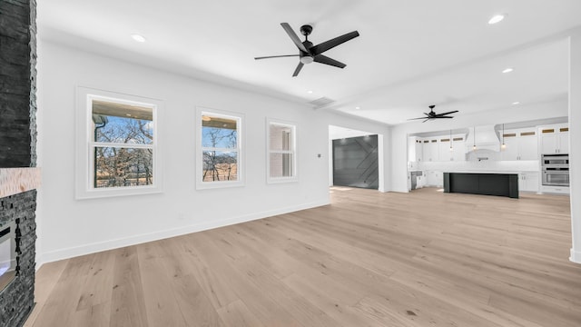 unfurnished living room with recessed lighting, ceiling fan, a fireplace, and light wood finished floors