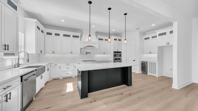 kitchen featuring a sink, stainless steel appliances, wine cooler, light wood-style floors, and custom exhaust hood