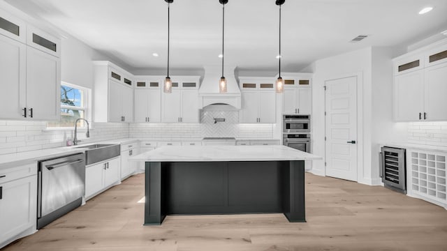 kitchen with visible vents, wine cooler, light wood-style flooring, appliances with stainless steel finishes, and a sink