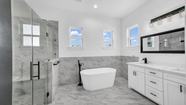 bathroom featuring vanity, a marble finish shower, a freestanding tub, recessed lighting, and marble finish floor