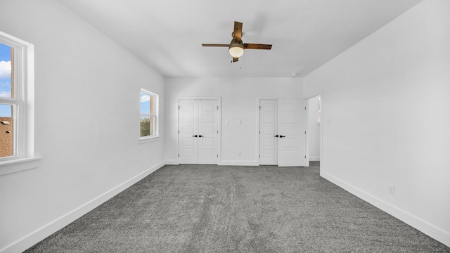 unfurnished bedroom with a ceiling fan, baseboards, and dark carpet