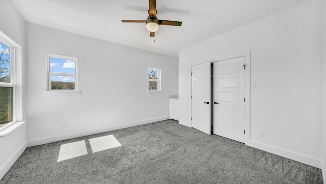 unfurnished bedroom with multiple windows, carpet floors, and baseboards