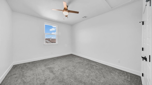 carpeted empty room featuring visible vents, a ceiling fan, and baseboards