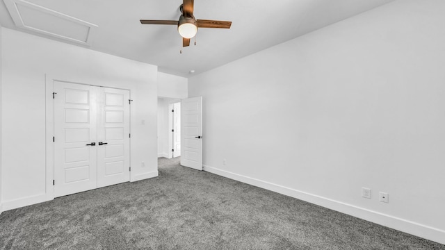 unfurnished bedroom featuring baseboards, ceiling fan, carpet, attic access, and a closet