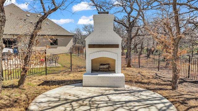 view of patio / terrace with fence and an outdoor brick fireplace