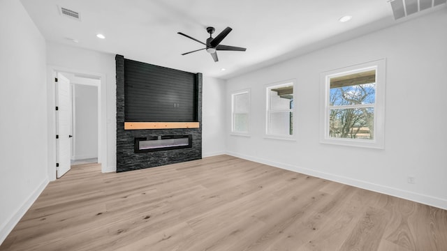 unfurnished living room with visible vents, light wood-style flooring, a fireplace, and baseboards