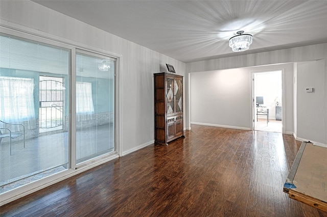 empty room featuring baseboards and dark wood-style flooring