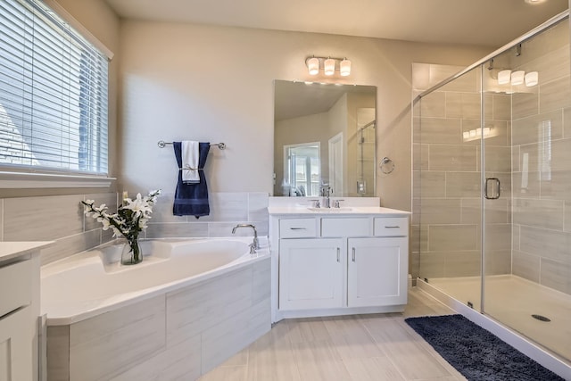 bathroom featuring vanity, a shower stall, and a bath