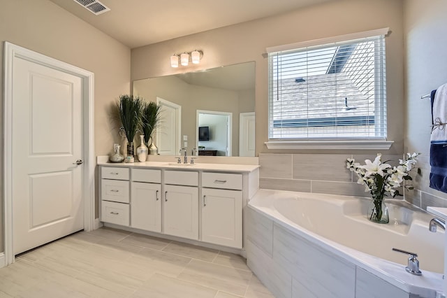 full bathroom with visible vents, vanity, and a garden tub