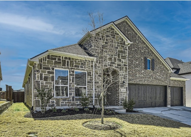 view of front of property featuring concrete driveway, fence, a front lawn, and stone siding