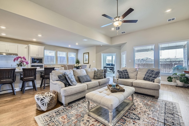 living room featuring recessed lighting, visible vents, baseboards, and light wood-style floors