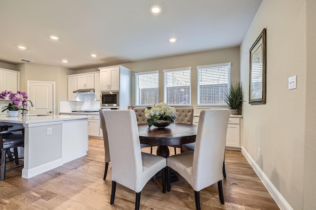 dining room with recessed lighting, baseboards, and light wood-style floors