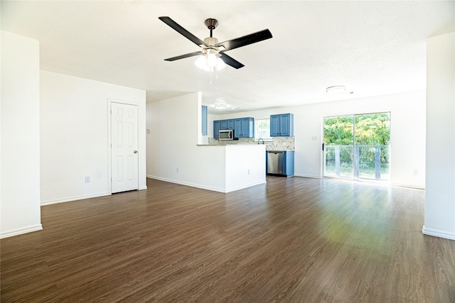 unfurnished living room featuring baseboards, a ceiling fan, and dark wood-style flooring