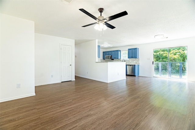 unfurnished living room with baseboards, a ceiling fan, and dark wood-style flooring