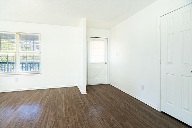 unfurnished bedroom with dark wood-style floors and baseboards