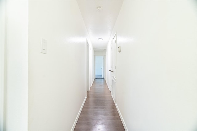 hall with baseboards and dark wood-style flooring