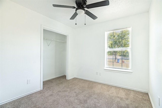 unfurnished bedroom with a ceiling fan, baseboards, a closet, a textured ceiling, and carpet flooring