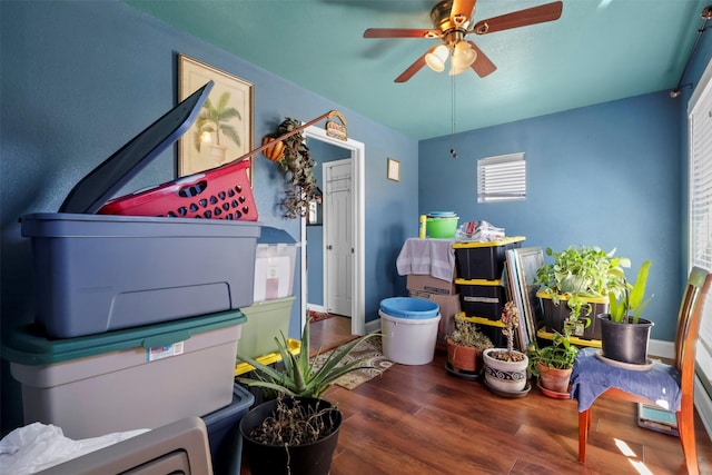 interior space with baseboards, a ceiling fan, and wood finished floors