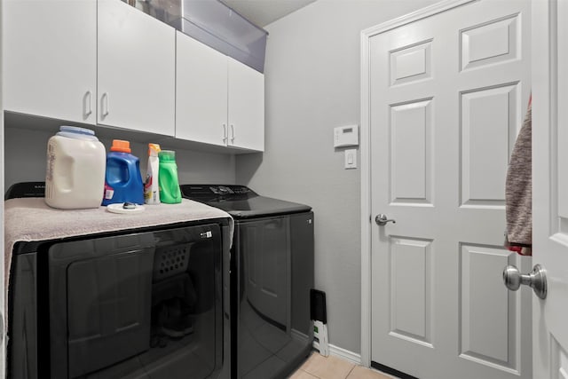 laundry area with washer and dryer, light tile patterned floors, cabinet space, and baseboards