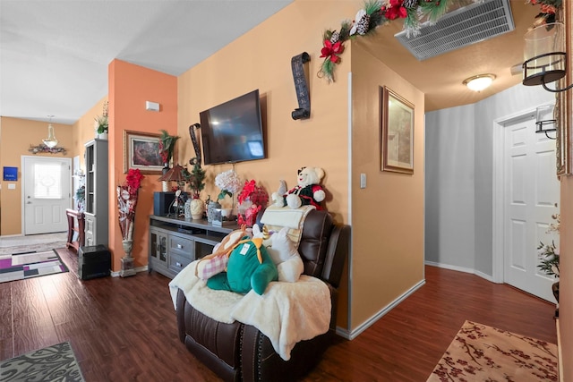 living room with visible vents, baseboards, and wood finished floors