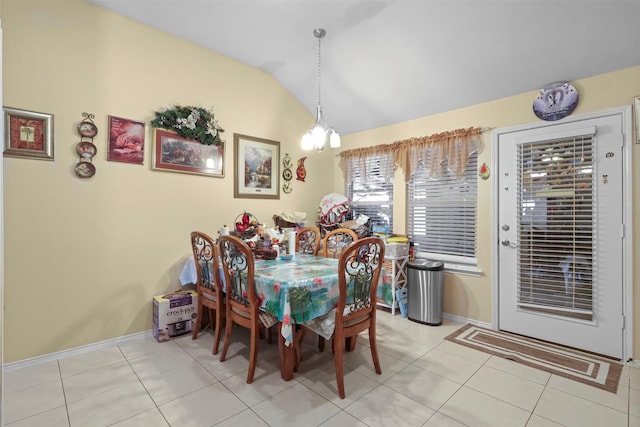 dining room featuring vaulted ceiling, light tile patterned floors, and baseboards