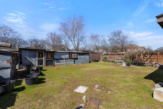 view of yard featuring an outbuilding, fence, and exterior structure