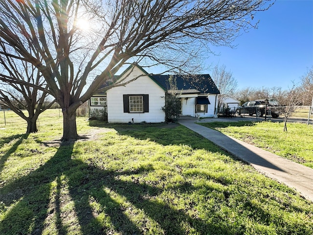 view of front facade with a front lawn and fence