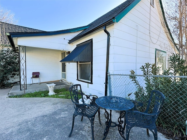 exterior space featuring a shingled roof and fence